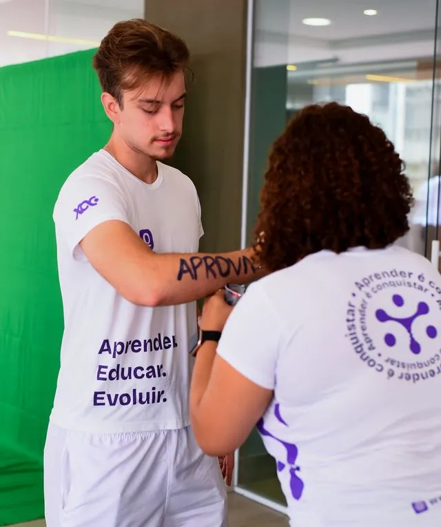 Aluno aprovado com APROVADO escrito no braço